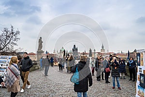 Prague, Bohemia / Czech Republic - November 2017: Tourists walking on the famous Charles Bridge Karluv most on rainy autumn day