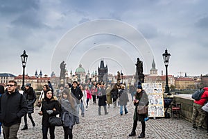 Prague, Bohemia / Czech Republic - November 2017: Tourists walking on the famous Charles Bridge Karluv most on rainy autumn day