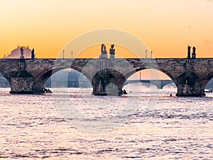 Prague bridge over a river with a city in the background