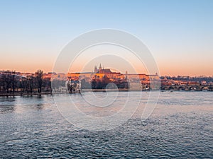 Prague bridge over a river with a city in the background