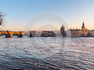 Prague bridge over a river with a city in the background