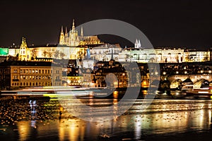 Prague castle and Charles bridge mirroring in Vltava river, nigh