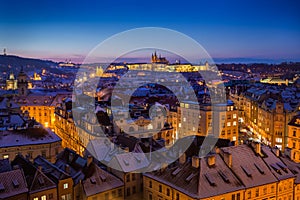 Prague Castle with snow rooftops during late christmas sunset with blue sky