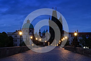 Prague, Charles Bridge in night. Lights on the bridge, built in medieval times. Twilight view of Prague with blue sky. Travelling