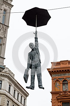 Prague, Czech Republic - 11 02 2018: Figure of a man with umbrella hanging over street