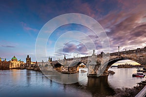 Prague, Czech Republic - Beautiful purple sunset and sky at the world famous Charles Bridge and St. Francis Of Assisi Church