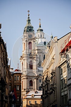 Prague, Czech Republic, 15 December 2022: View of Baroque Church of Saint Nicholas, green dome and bell tower with clock, sunny