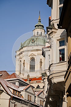 Prague, Czech Republic, 15 December 2022: View of Baroque Church of Saint Nicholas, green dome and bell tower with clock, sunny