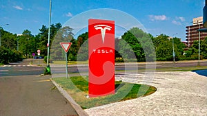 Big red column with Tesla sign for marking a car dealer selling Tesla cars