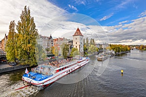 Dramatic view on Vltava river, tourist ship, Prague city center, Saints Vitus Cathedral and Prague Castle, Prague, Czech Republic