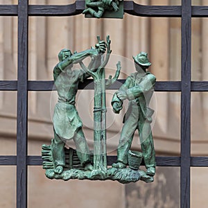 Prague, Czech Republic - September 23, 2019. A copper bas-relief on the fence of St. Vitus Cathedral depicting rural life