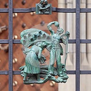 Prague, Czech Republic - September 23, 2019. A copper bas-relief on the fence of St. Vitus Cathedral depicting rural life