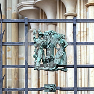 Prague, Czech Republic - September 23, 2019. A copper bas-relief on the fence of St. Vitus Cathedral depicting rural life