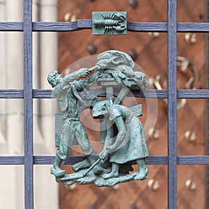 Prague, Czech Republic - September 23, 2019. A copper bas-relief on the fence of St. Vitus Cathedral depicting rural life