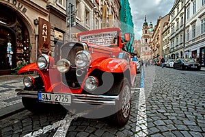 Prague, Czech Republic, September 15, 2017: touristic vintage classic red hot rod car on a cobble road