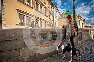 Prague, Czech Republic, September 15, 2017: Young women tourist with a puppy dog and a backpack