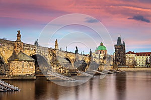 Prague, Czech Republic - The world famous Charles Bridge Karluv most with a beautiful purple sky and sunset photo