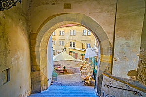 The view through the medieval arch on outdoor restaurant on Radnicke Schody staircases in Hradcany district of Prague, Czechia