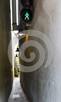 Prague. The narrowest street Vinarna Certovka, with the traffic light for pedestrians and one-way traffic