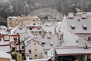 Prague old town red tiled roof under snow in winter day, European medieval city view, ancient architecture, touristic view, Lesser