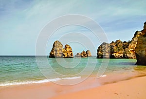 Praia do Camilo, beach without people and cliffs in the middle of its turquoise waters in the Portuguese Algarve