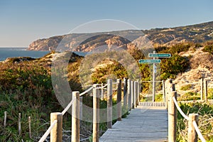 Praia do Guincho Beach pathway with indications to the beach coastline and sand dunes, in Portugal