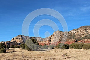 A prairie like plateau on the Brins Mesa Trail surrounded by red sandstone and white limestone mountaintops