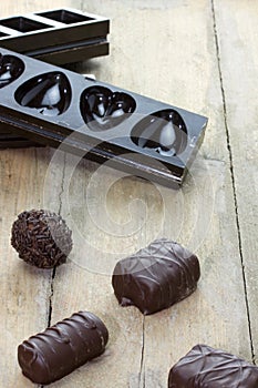 Pralines with chocolate molds on the background