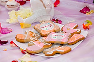 Pram shaped gingerbread cookies on white plate. Candy bar with sweets for girl birthday party.