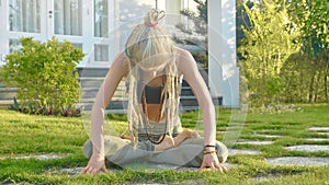 Pranayama yoga breath exercise by a young woman in the backyard of her house.