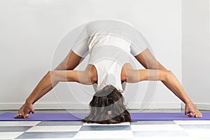 Prasarita Padottanasana pose. Symmetric yoga pose done by woman