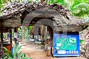 Vallee de Mai Nature Reserve entrance gate with thatched roof with dried palm tree leaves and map of a reserve..