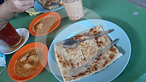 Prata curry is a special dish for breakfast at a famous cafe on the island caled Belakang Padang in the city of Batam