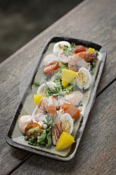 Prawn and egg salad on rustic wood table