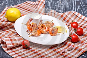 prawn kebabs with lemon on skewers in restaurant serving