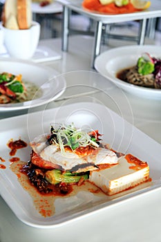 Prawn seafood dish serve with tofu and sauce and vegetable on top