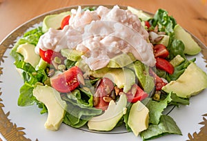 Prawn in a seafood sauce and succulent red tomatoes in a salad with avocado and lettuce