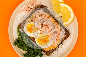 Prawn or shrimp and boiled egg open face sandwich on rye bread