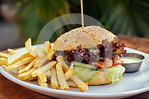 Prawns burger and french fry on table tropical sea ,palms tree and beach background