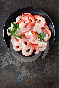 Prawns on plate. Shrimps, prawns. Seafood. Top view. Dark background