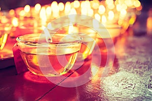 Pray candle glass on wood table in chinese temple