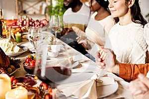 Happy family celebrate Thanksgiving day, sitting at table with roasted turkey and holiday traditional food, dishes.