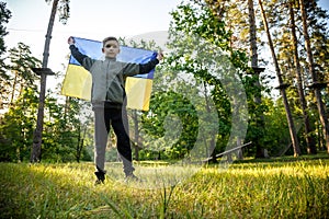 Pray for Ukraine. boy with Ukrainian flag running the summer par