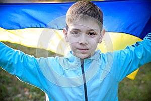 Pray for Ukraine. boy with Ukrainian flag running the summer par