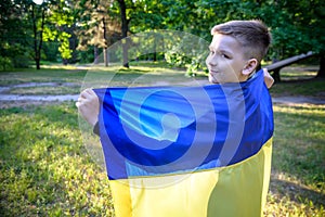 Pray for Ukraine. boy with Ukrainian flag running the summer par