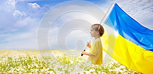 Pray for Ukraine. Child with Ukrainian flag