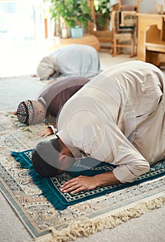 Prayer is as important as breathing. a young muslim couple and their son praying in the lounge at home.