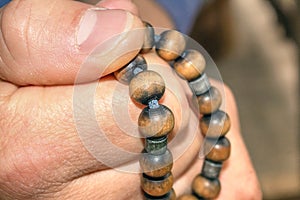 Prayer beads. Belief in God. Hold a religious attribute