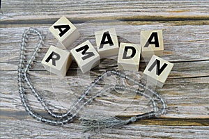 Prayer beads and wooden cubes with text RAMADAN