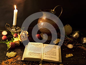 A prayer book and a candle on a dark table. Preparing for Christmas. Religion, Christianity